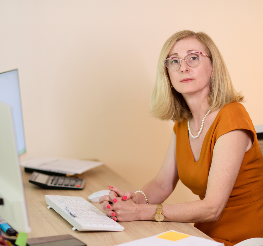 Fotografía de NATALIA PRYGNAR sentada en su puesto de trabajo, se ve también la mesa con el ordenador